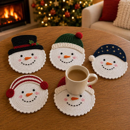 Fünf gehäkelte Schneemann-Untersetzer mit Tasse vor dem Kamin